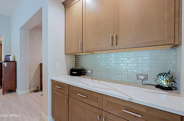 kitchen with light stone countertops and decorative backsplash