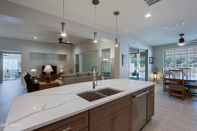 kitchen featuring ceiling fan, dishwasher, sink, and hanging light fixtures