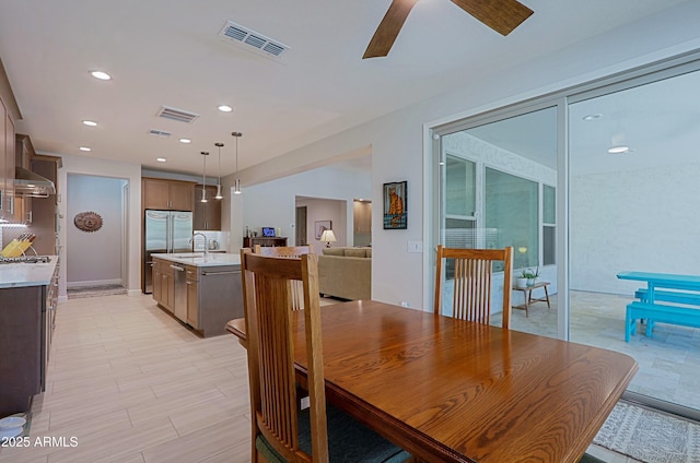 dining space featuring sink and ceiling fan