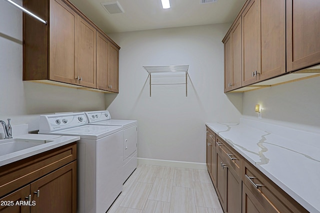 washroom with separate washer and dryer, sink, and cabinets