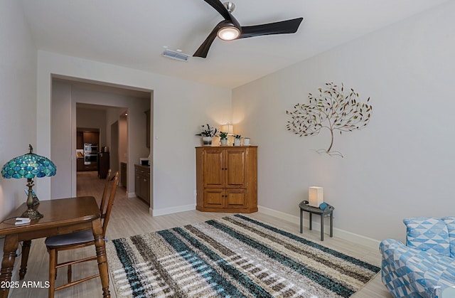 sitting room with ceiling fan and light wood-type flooring