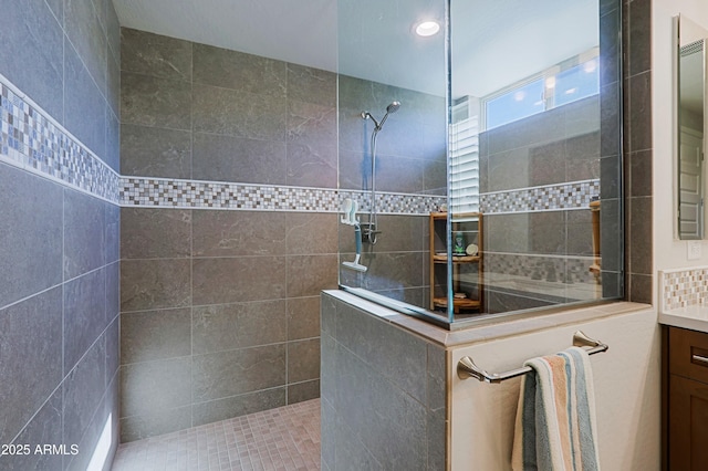 bathroom featuring vanity and tiled shower