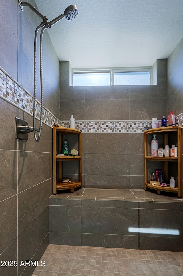 bathroom featuring a shower, a healthy amount of sunlight, and a textured ceiling