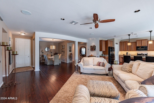 living room with dark wood-type flooring and ceiling fan