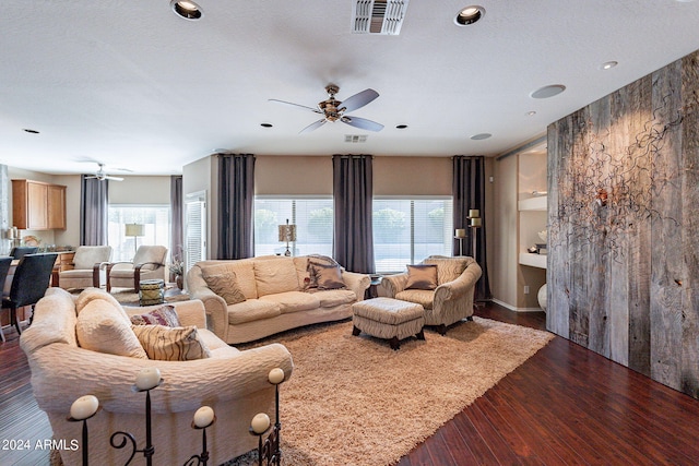 living room featuring ceiling fan and dark hardwood / wood-style floors