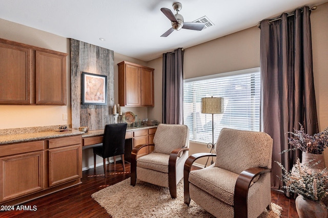 sitting room with ceiling fan and dark wood-type flooring