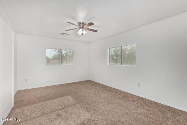 empty room featuring visible vents, baseboards, carpet, and ceiling fan