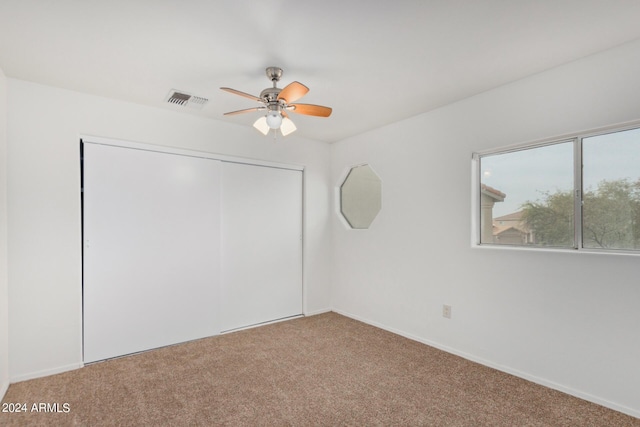 unfurnished room featuring visible vents, carpet floors, and ceiling fan