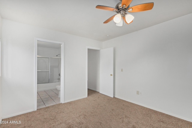 unfurnished bedroom with tile patterned flooring, baseboards, carpet flooring, ensuite bath, and a ceiling fan