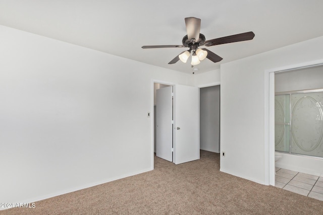 unfurnished bedroom with light tile patterned floors, light carpet, a ceiling fan, and ensuite bathroom