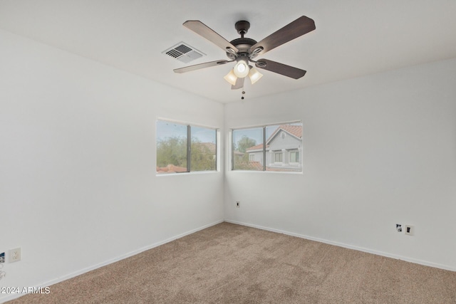 empty room featuring baseboards, visible vents, a ceiling fan, and carpet