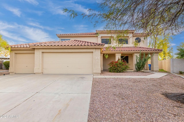 mediterranean / spanish house featuring fence, driveway, stucco siding, a garage, and a tile roof