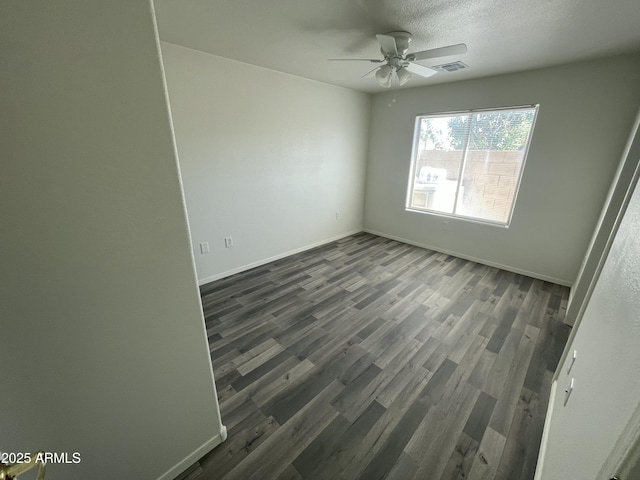 empty room with ceiling fan, dark hardwood / wood-style floors, and a textured ceiling