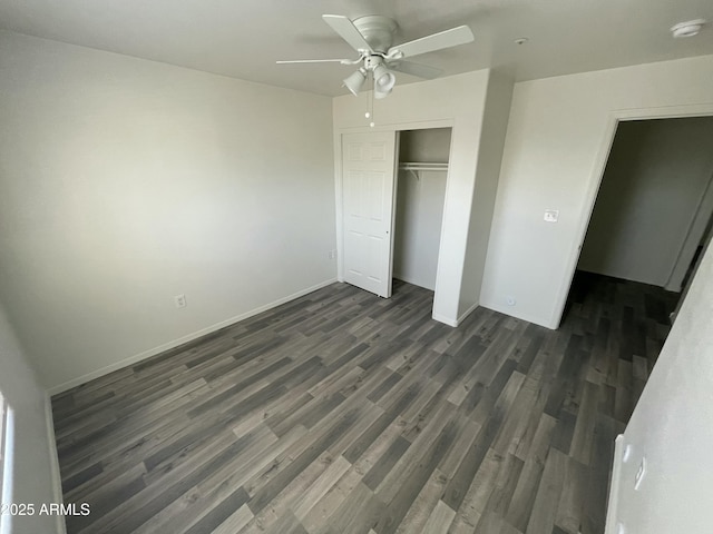 unfurnished bedroom featuring dark hardwood / wood-style floors, ceiling fan, and a closet