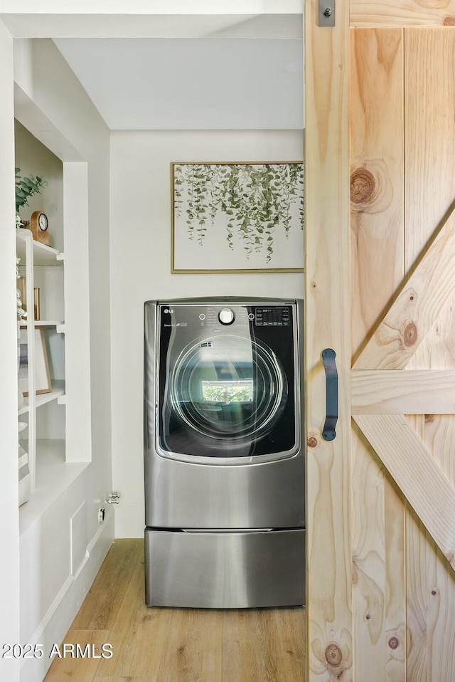 laundry room with wood finished floors, washer / dryer, and laundry area