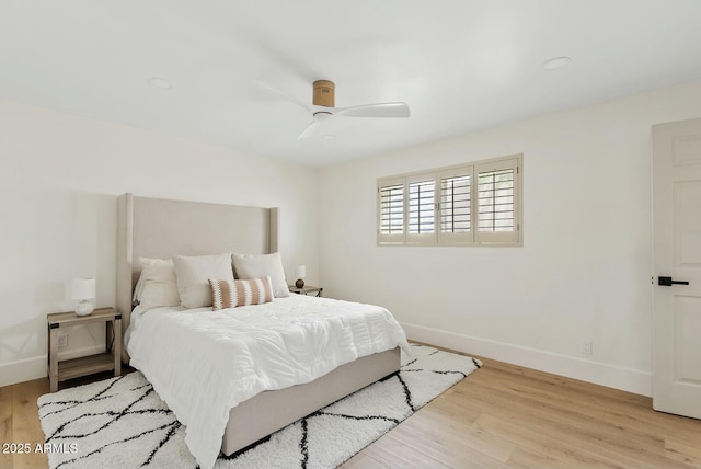 bedroom featuring a ceiling fan, light wood-style flooring, and baseboards
