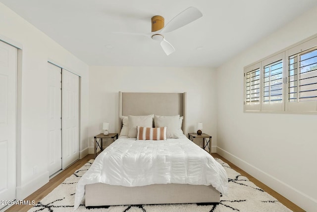 bedroom with ceiling fan, wood finished floors, and baseboards
