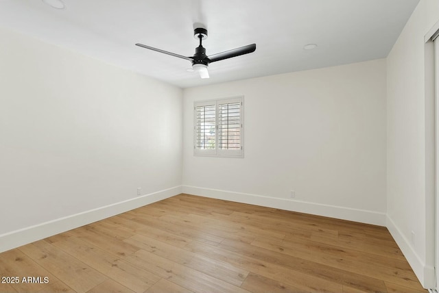 unfurnished room with light wood-type flooring, a ceiling fan, and baseboards