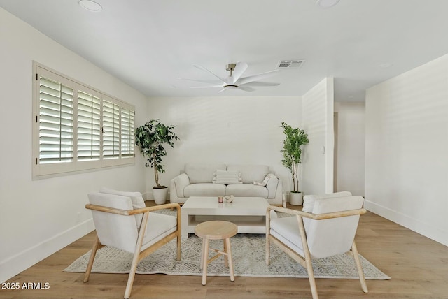 interior space with baseboards, visible vents, wood finished floors, and a ceiling fan