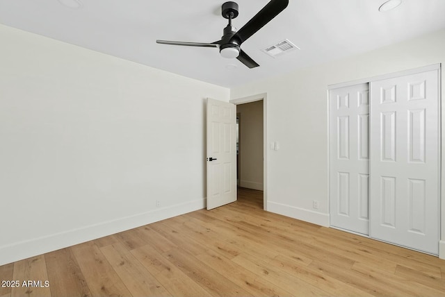 unfurnished bedroom featuring visible vents, a closet, baseboards, light wood-type flooring, and a ceiling fan