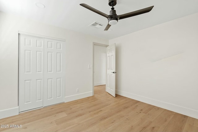 unfurnished bedroom with ceiling fan, visible vents, a closet, baseboards, and light wood-type flooring