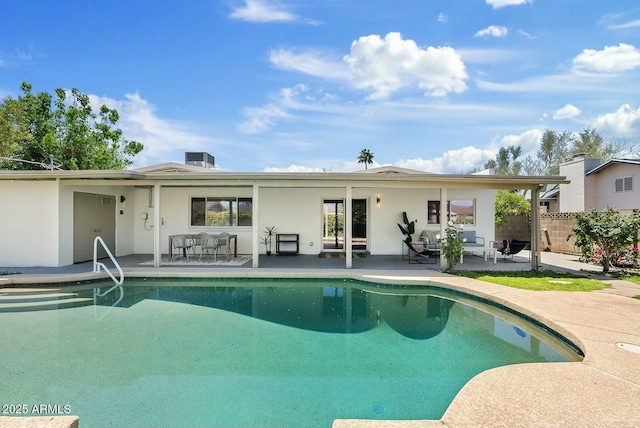 back of property featuring a patio, a fenced in pool, stucco siding, and fence