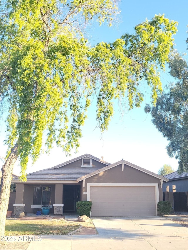 17257 W Papago St, Goodyear, AZ 85338 - ranch-style house featuring stucco siding, a garage, concrete driveway, stone siding, and a tile roof