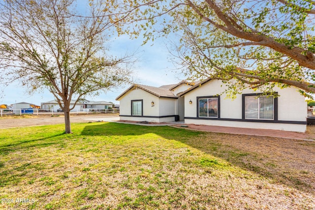 rear view of property featuring a lawn