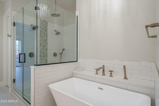 bathroom featuring plus walk in shower and tile walls