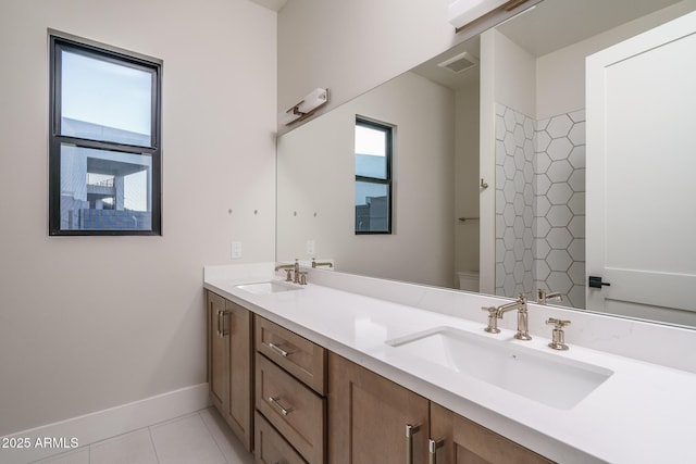 bathroom with tile patterned flooring, vanity, a wealth of natural light, and toilet