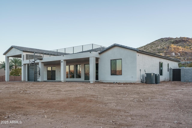 rear view of property with cooling unit and a mountain view