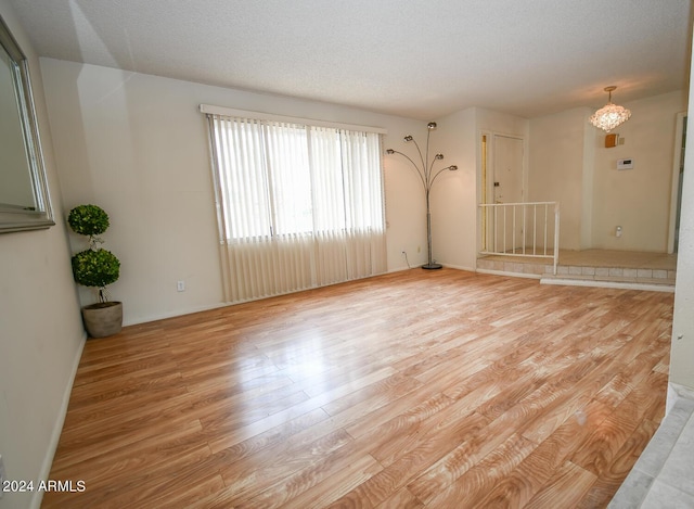 empty room featuring light hardwood / wood-style floors and a textured ceiling