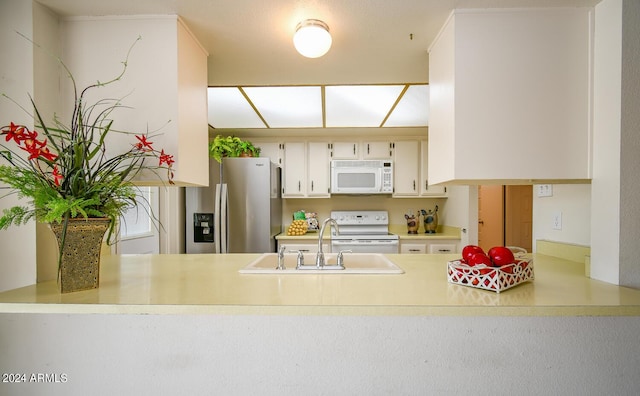 kitchen featuring sink, white appliances, and kitchen peninsula