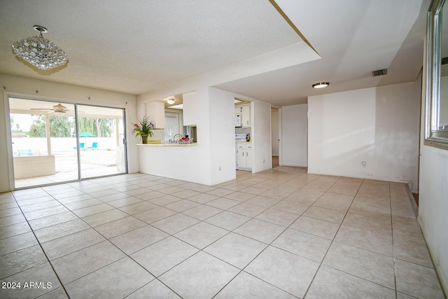 empty room with light tile patterned floors and a textured ceiling