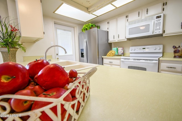 kitchen featuring white appliances, sink, and white cabinets