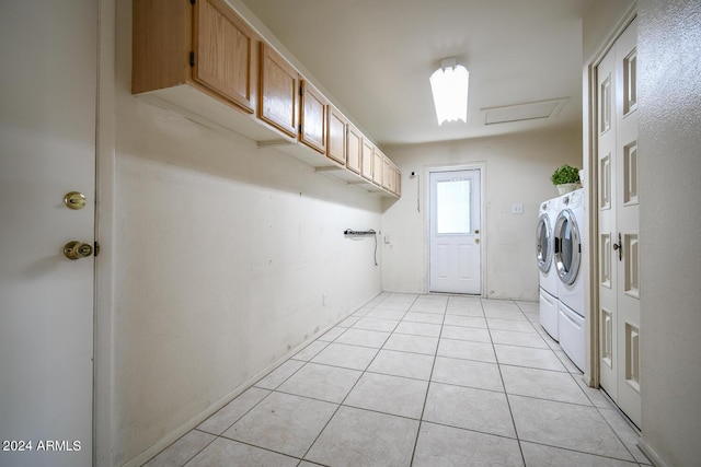 washroom featuring cabinets, separate washer and dryer, and light tile patterned floors