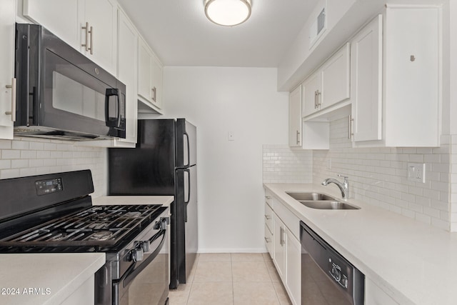 kitchen with black appliances, decorative backsplash, light tile patterned floors, and white cabinets