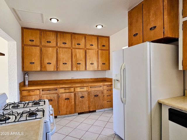 1374 S Naco Hwy, Bisbee, AZ 85603 - kitchen with white appliances, brown cabinets, light countertops, and light tile patterned flooring