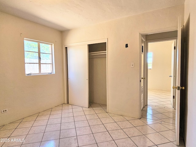 1374 S Naco Hwy, Bisbee, AZ 85603 - unfurnished bedroom featuring light tile patterned flooring and a closet