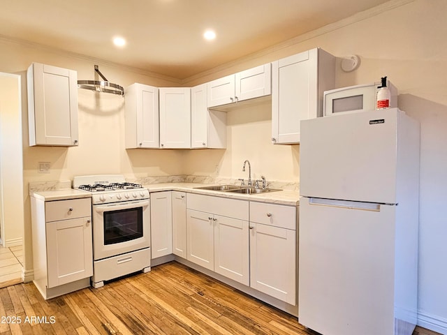 1374 S Naco Hwy, Bisbee, AZ 85603 - kitchen featuring white appliances, a sink, light countertops, light wood-type flooring, and white cabinets