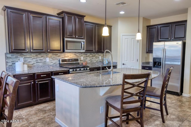 kitchen with pendant lighting, sink, stainless steel appliances, and dark brown cabinets