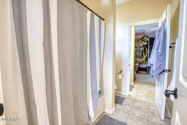 bathroom featuring toilet, shower / tub combo, and tile patterned floors