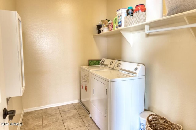 clothes washing area with washer and dryer and light tile patterned floors