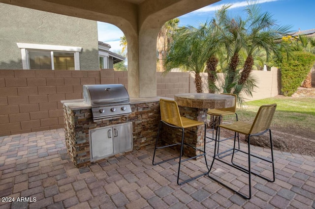 view of patio / terrace with an outdoor kitchen, a bar, and grilling area