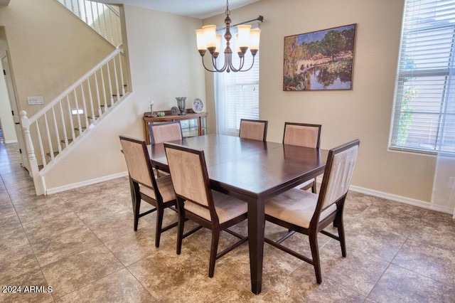 dining area featuring tile patterned flooring and a notable chandelier