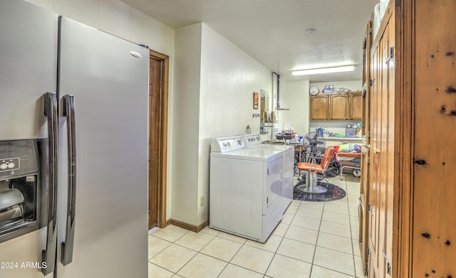 washroom with light tile patterned flooring, a textured ceiling, and independent washer and dryer