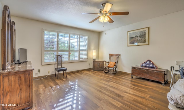 sitting room with hardwood / wood-style floors and ceiling fan