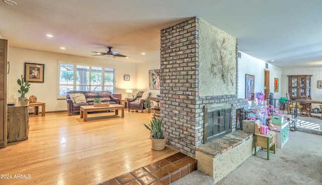 carpeted living room featuring ceiling fan and a fireplace