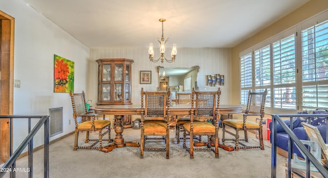 dining area with light carpet and an inviting chandelier