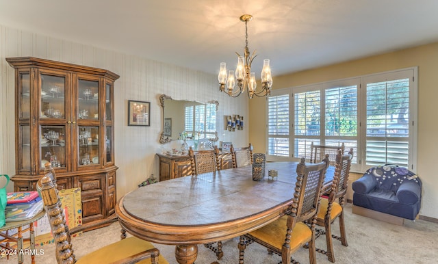 carpeted dining area with a healthy amount of sunlight and an inviting chandelier